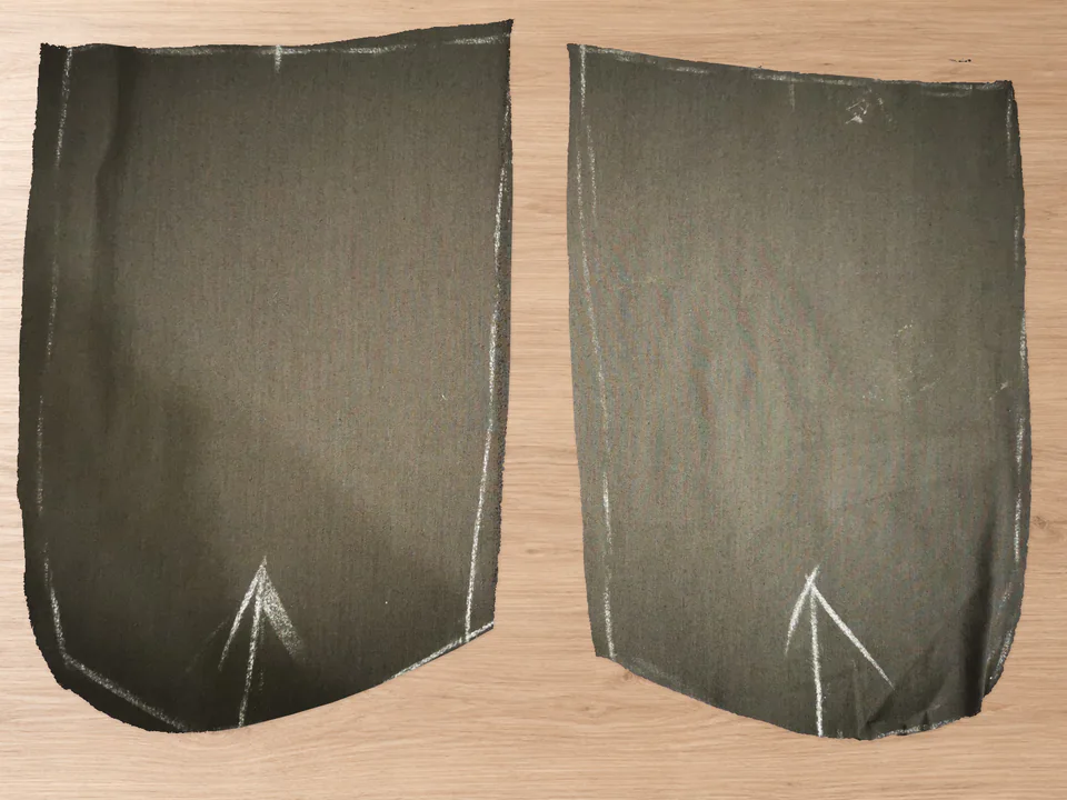 Two separate brown pocket-lining pieces, cut as a mirrored pair with curved bottoms and chalk markings.
