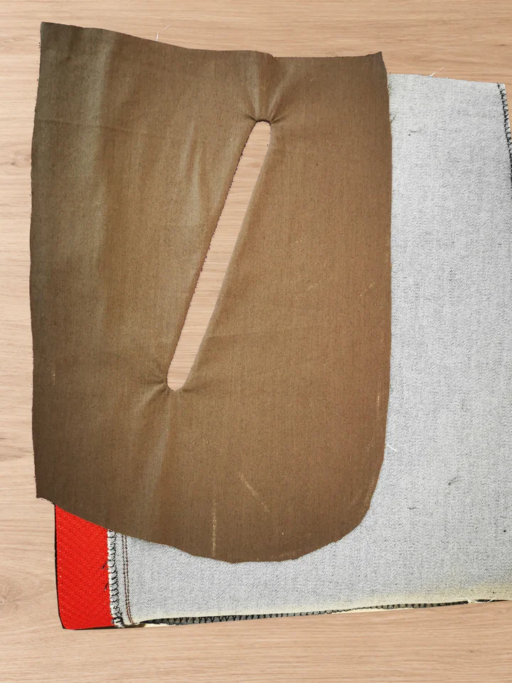 Whole brown pocket lining lying against the grey reverse of the trouser front after turning through the slot.