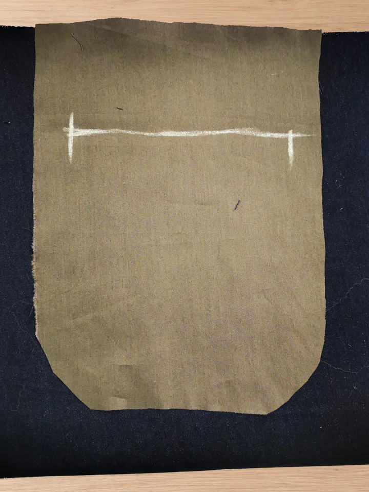 Cut brown back-pocket lining laid over the navy trouser back.