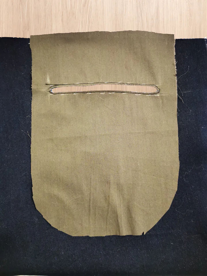 Cut horizontal back-pocket slot in brown lining with seam allowance visible inside the stitched outline.