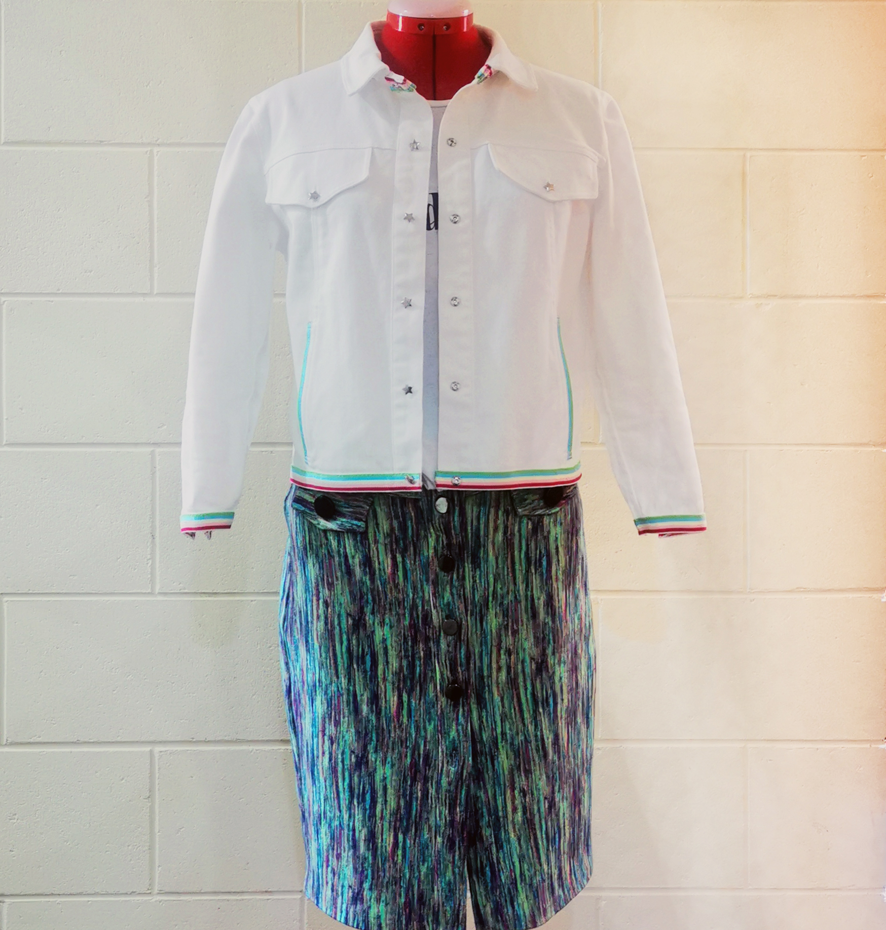 White denim jacket displayed with a multicoloured button-front pencil skirt.
